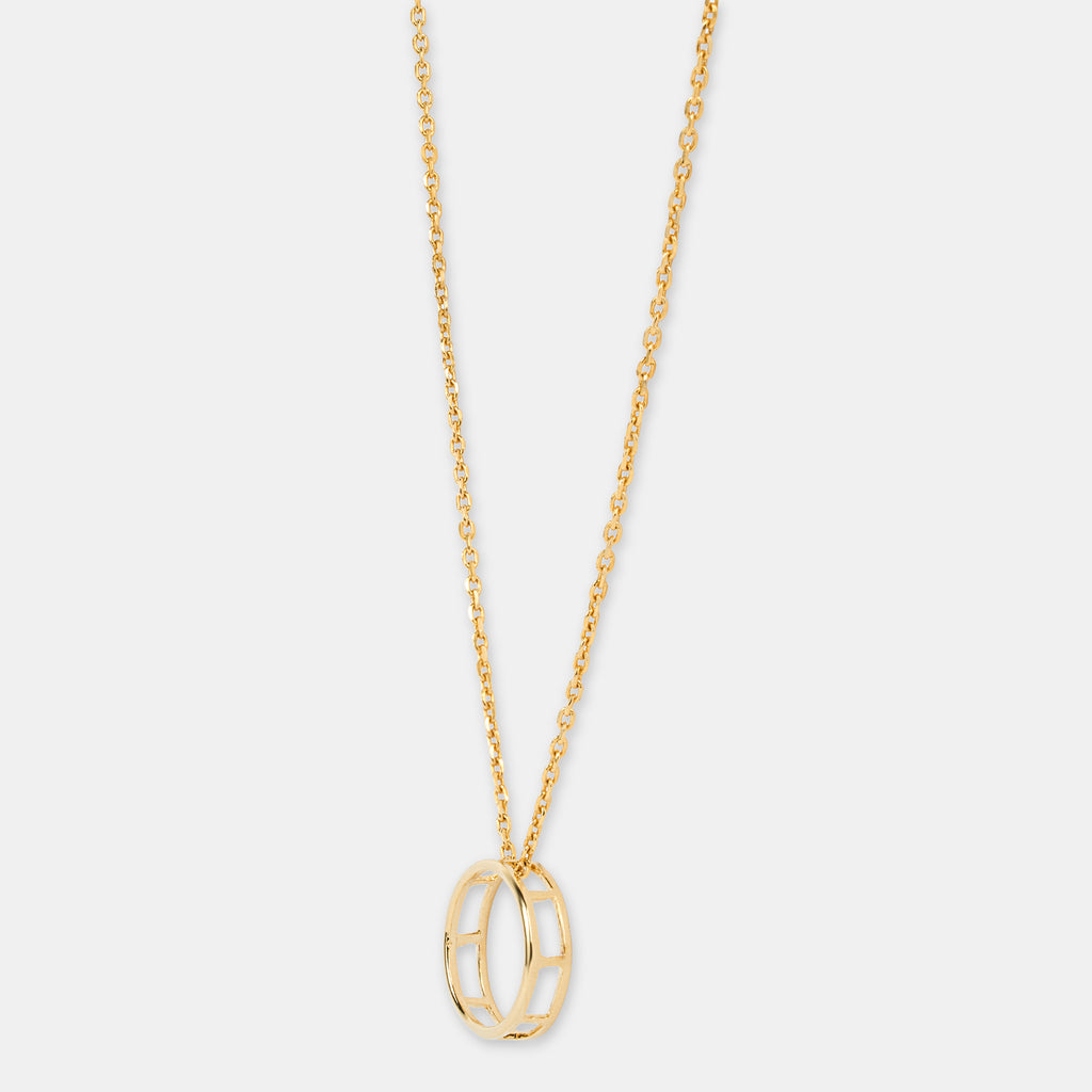 Gold necklace with a unique full moon pendant on a light gray background 