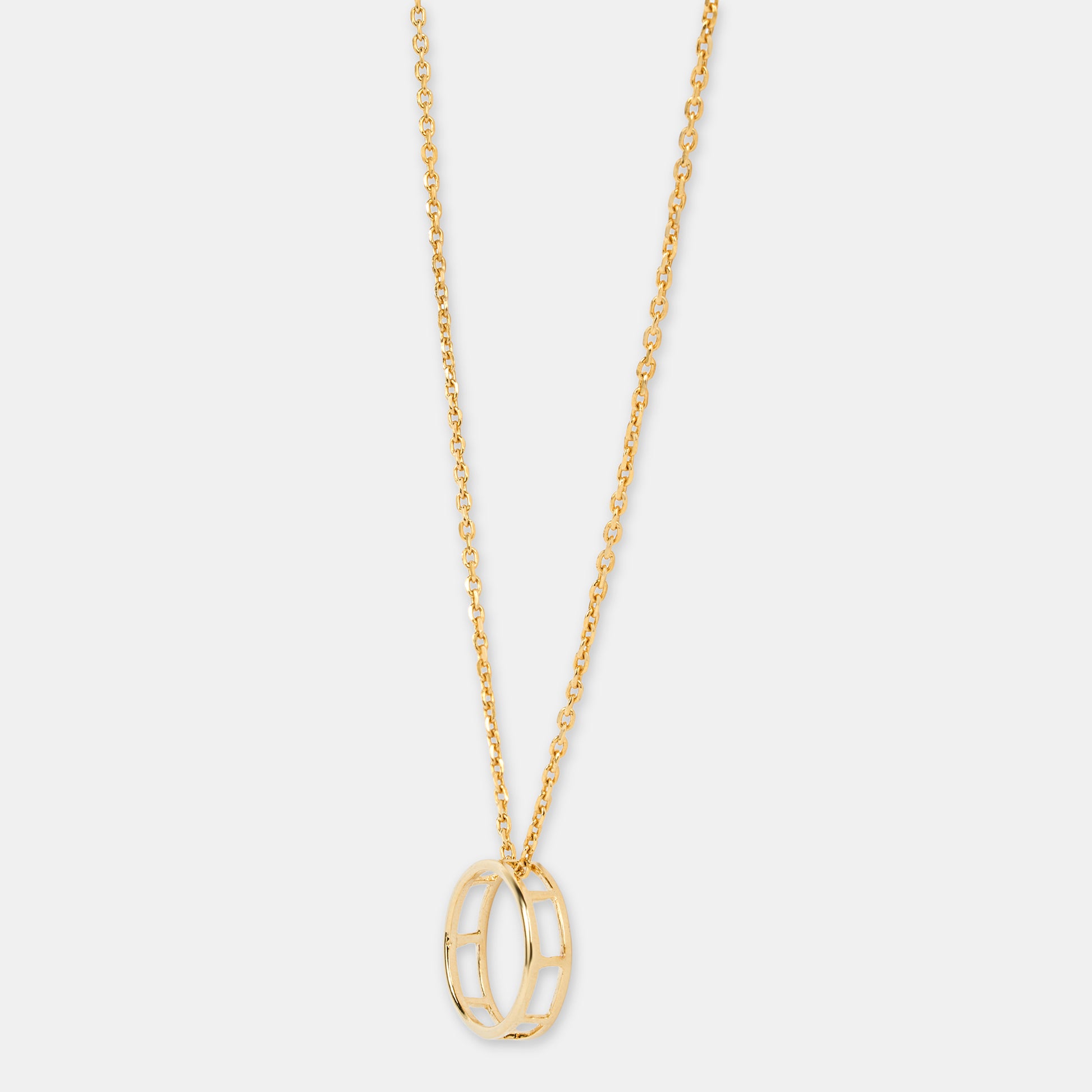 Gold necklace with a unique full moon pendant on a light gray background 