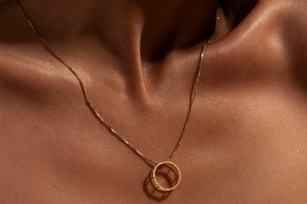 Gold necklace with a unique full moon pendant with american diamonds on skin