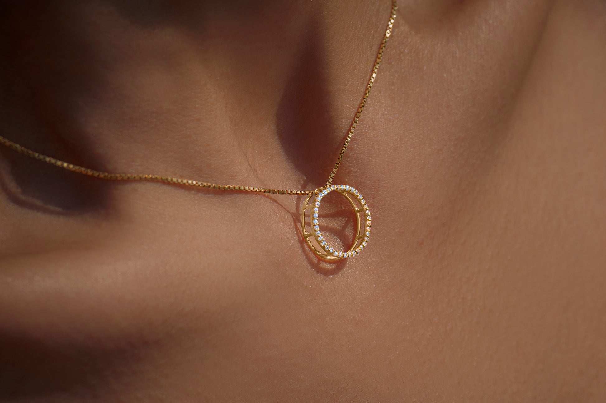 Gold necklace with a unique full moon pendant with american diamonds on skin