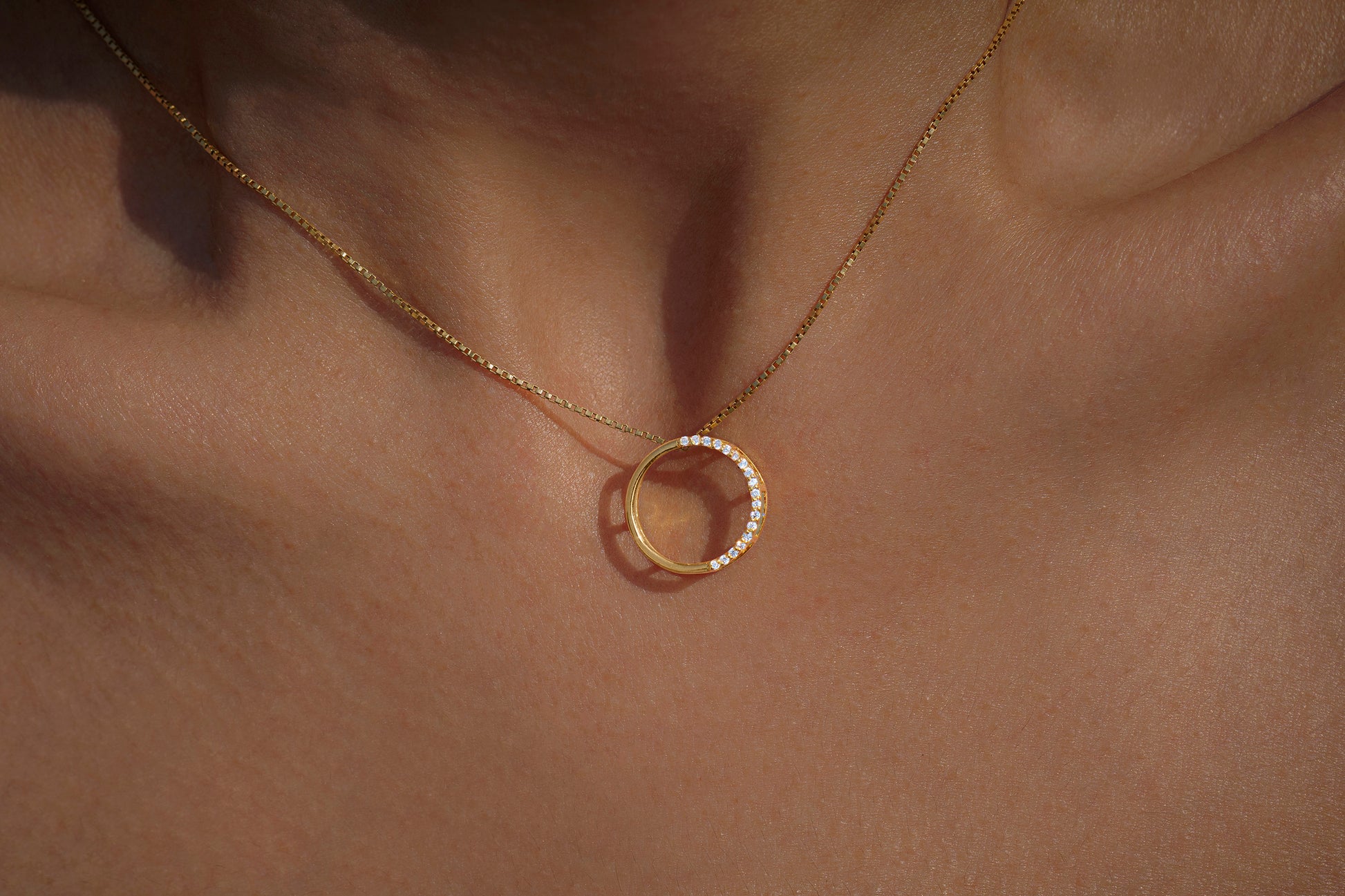 Gold necklace with a unique full moon pendant with american diamonds on skin