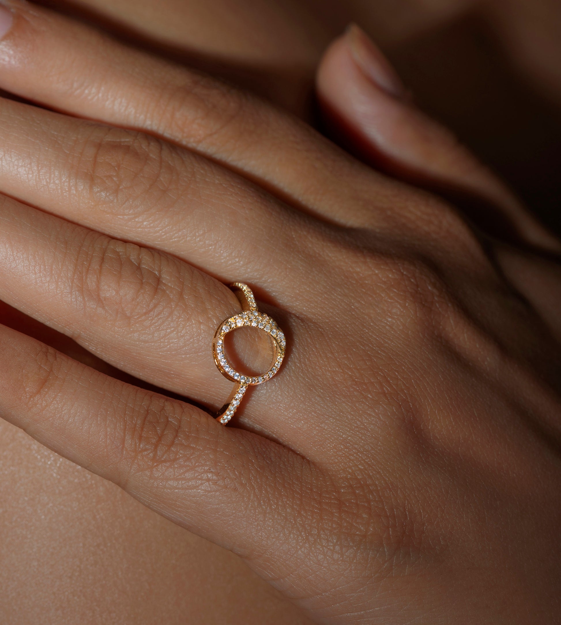 A person wearing a ring with a waning gibbous phase design, crafted from sterling silver with a high polish finish, featuring American diamonds.