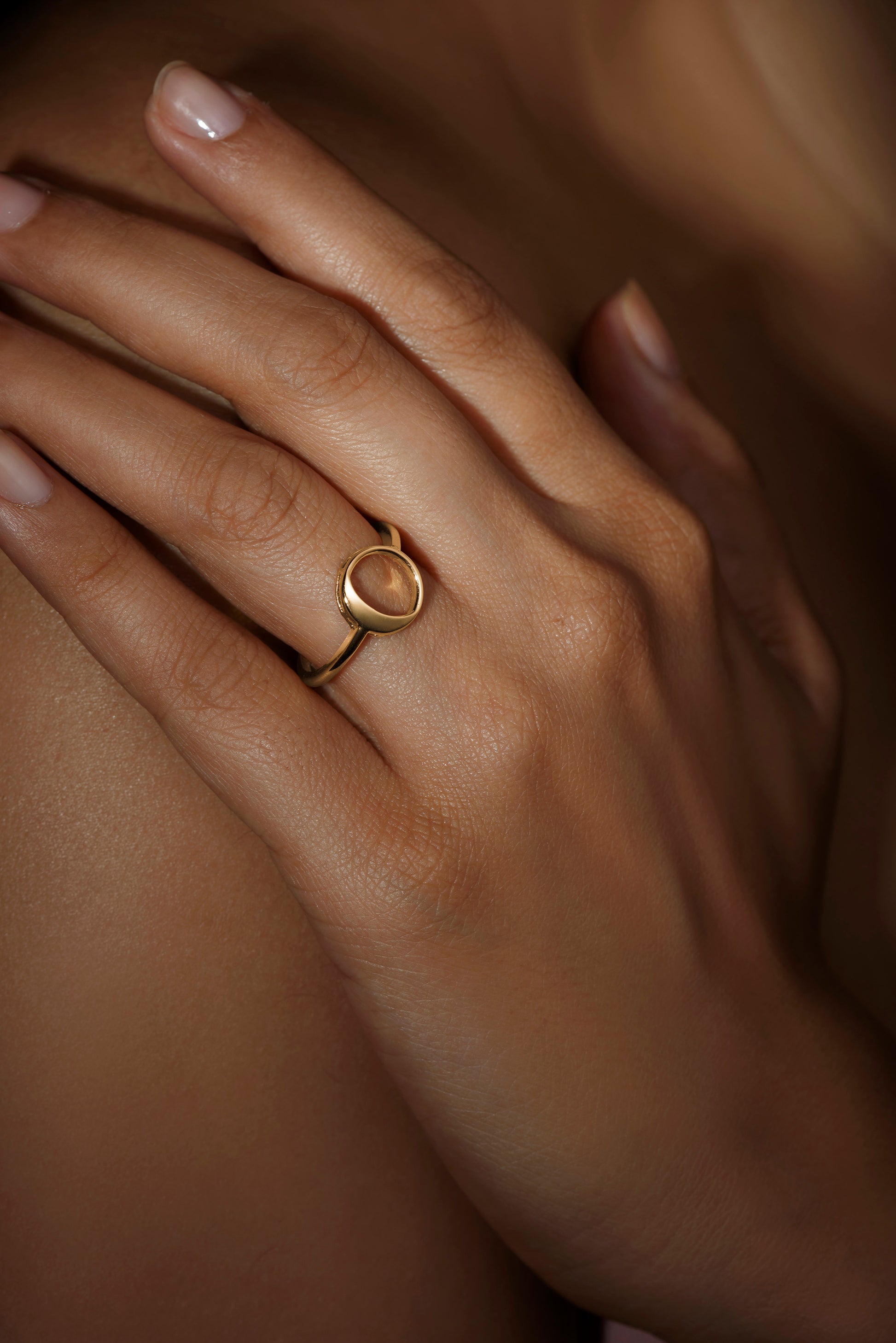 A person wearing a ring with a waning gibbous phase design, crafted from sterling silver with a high polish finish